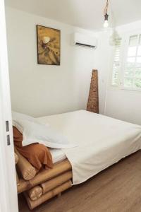 Schlafzimmer mit einem Bett mit weißer Bettwäsche in der Unterkunft Villa F4 chic avec jacuzzi en Martinique in Le Lamentin