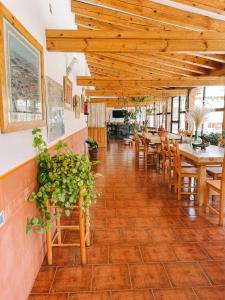 un restaurante con techos de madera, mesas y sillas en Hotel Rural El Perdigón en El Perdigón