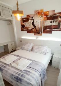 1 dormitorio con 1 cama y una pintura en la pared en Hostal Kokkola, en Fuengirola