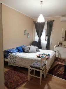 1 dormitorio con 1 cama y 1 silla en Dimora Buglio Valguarnera, en Valguarnera Caropepe