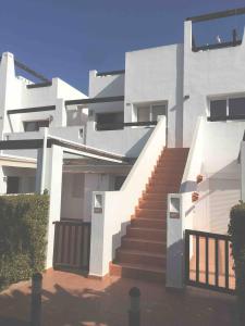 une maison blanche avec des escaliers en face de celle-ci dans l'établissement Naranjos Condado, à Alhama de Murcia