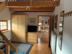 a living room with a television and a wooden floor at Ferienwohnung Bacher in Edling