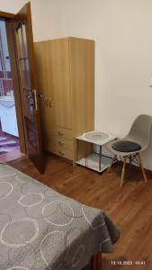 a bedroom with a bed and a chair and a table at Villa Homestay Nad Helmrovkou in Prague