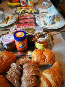 un tavolo con croissant e altri tipi di pane e marmellate di Bed and Breakfast Lek & Jo 