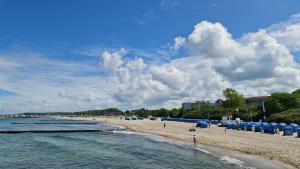 una playa con sombrillas azules y gente en ella en Ostseetraum, en Kühlungsborn