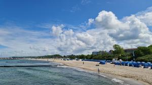 a beach with blue beach umbrellas and people on it at Ostseetraum in Kühlungsborn