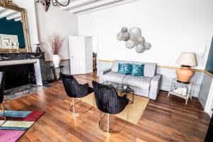 ein Wohnzimmer mit einem Sofa und einem Kamin in der Unterkunft Le Regisseur in Brissac-Quincé