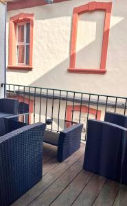 eine Terrasse mit Stühlen und einem Geländer sowie ein Gebäude in der Unterkunft Ferienwohnung Bloom in Bernkastel-Kues
