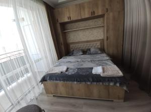 um quarto com uma cama e uma cabeceira em madeira em Meskheti Tower Unit 93 em Akhaltsikhe