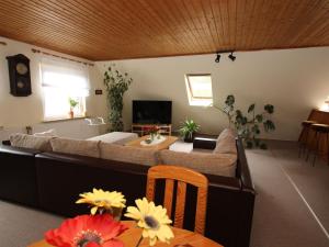 een woonkamer met een bank en een tafel bij Apartment, Moorhusen in Südbrookmerland