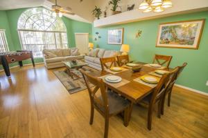 un soggiorno con tavolo e sedie in legno di 3 Bedroom Resort Condo 8 Miles to Disney Pool Free Parking a Kissimmee
