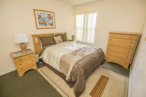 una camera da letto con un letto, un comò e una finestra di 3 Bedroom Resort Condo 8 Miles to Disney Pool Free Parking a Kissimmee Altre 6 foto