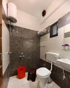 une salle de bains avec toilettes et lavabo dans l'établissement Coral Villa, à Panchgani