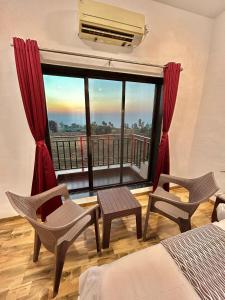 une chambre avec une grande fenêtre offrant une vue dans l'établissement Coral Villa, à Panchgani