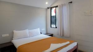 um quarto com uma cama grande e uma janela em 12 Monks Hostel em Arambol