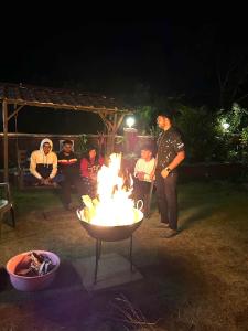 un groupe de personnes assises autour d'un feu la nuit dans l'établissement Coral Villa, à Panchgani