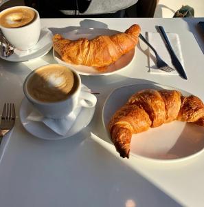 un tavolo con un piatto di croissant e una tazza di caffè di B&B Sirio a Villa San Giovanni