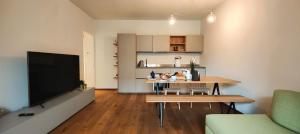 ein Wohnzimmer mit einem Tisch und eine Küche mit einem TV in der Unterkunft Hostdomus - Lagrange Luxury Apartments in Turin