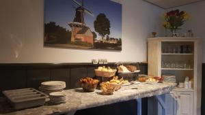 een tafel met borden en manden met eten erop bij City Hotel Winschoten in Winschoten