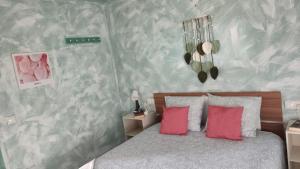 Un dormitorio con una cama con dos almohadas rojas. en "La Cala de Mijas Bright Apartment with Sea Views Near the Beach", en La Cala de Mijas 30 fotos más