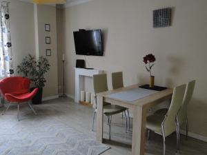 een woonkamer met een tafel en stoelen en een televisie bij Apartament w centrum Starego Miasta 1 in Olsztyn