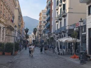 un gruppo di persone che camminano per una strada con edifici di Salerno4Seasons a Salerno
