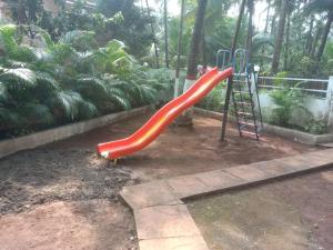 a playground with a red slide in a yard at Sea breeze Private Pool Villa - alibaug by 29 Bungalow in Nagaon