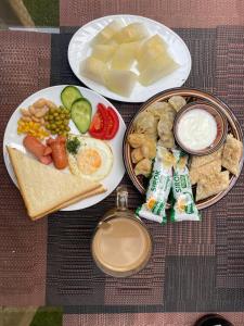 - une table avec deux assiettes de nourriture et une bouteille de boisson dans l'établissement Orion Hotel Tashkent, à Tachkent