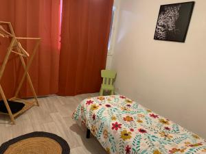 1 dormitorio con 1 cama y 1 silla verde en Appartement idéal famille 3 chambres, en Mâcon
