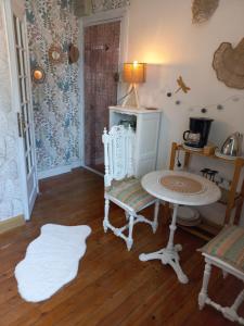a living room with a table and chairs and a table at charmante studette a quiberon plage in Quiberon