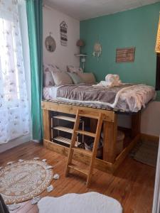 a bed in a room with a wooden table at charmante studette a quiberon plage in Quiberon