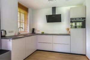 a kitchen with white cabinets and a sink at Buitenplaats Appelhoeve in Appelscha