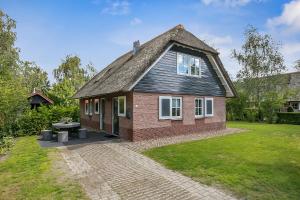 una pequeña casa de ladrillo rojo con techo en De Appelhoeve, en Appelscha