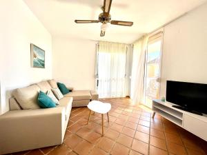 ein Wohnzimmer mit einem Sofa und einem Flachbild-TV in der Unterkunft Las Terrazas Islantilla in Huelva