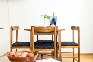 a table with two chairs and a bowl of apples at Sunny and Stylish - Free Parking - 15 min to Center in Vienna