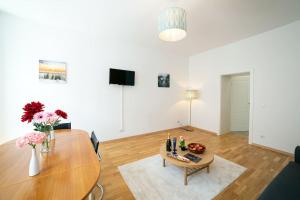 a living room with a wooden table and a dining room at Sunny and Stylish - Free Parking - 15 min to Center in Vienna