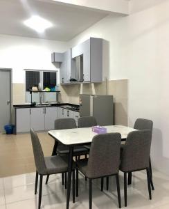 un tavolo da pranzo e sedie in una cucina di Salak Cemara Homestay Klia/Klia2 a Sepang