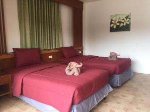 two beds in a hotel room with stuffed animals on them at Praew Guesthouse in Phra Ae beach