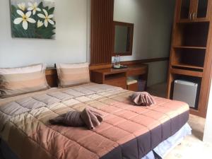 a bedroom with a bed with two pillows on it at Praew Guesthouse in Phra Ae beach