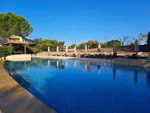 uma piscina com cadeiras e água azul em Appartement F2 dans le golf de Saint-Endréol em La Motte