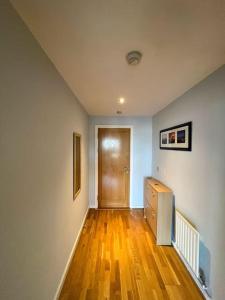 a room with a hallway with a wooden floor and a door at The Clayton Charming One Bedroom Apartment in Dublin
