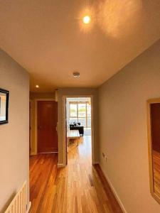 an empty living room with a wooden floor and a hallway at The Clayton Charming One Bedroom Apartment in Dublin