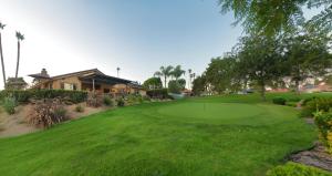 a golf course with a green and a house at Cottage On The Greens - Studio in Poway