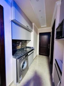a kitchen with a washing machine in a room at Sia Lagoon 2 BR Porto Golf Marina Apartment with Garden Families only in El Alamein