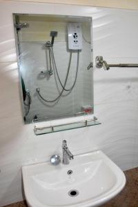 a bathroom with a sink and a soap dispenser at Forest View Villa (Bangalahatha) in Nuwara Eliya