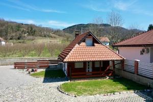 een klein huis met een oranje dak op een veld bij Medi Apartman Nature Connection Drina in Bajina Bašta
