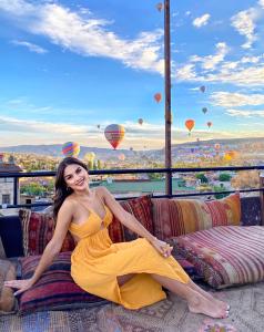 a woman in a yellow dress sitting on a couch with balloons at View Cave Hotel in Göreme