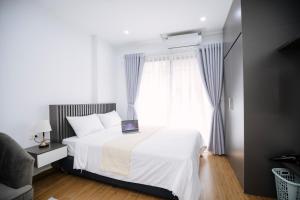 una camera con un letto bianco e una finestra di Alaya 10 Apartment a Hanoi
