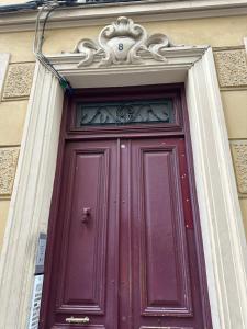 a burgundy door with avisor above it on a building at Beau studio au cœur de Nice in Nice