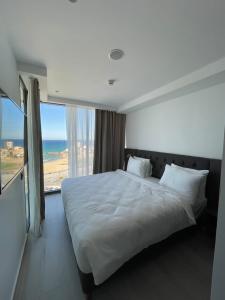 1 dormitorio con cama grande y ventana grande en BOUMERDES PLAZA Hôtel & Spa en Boumerdes
